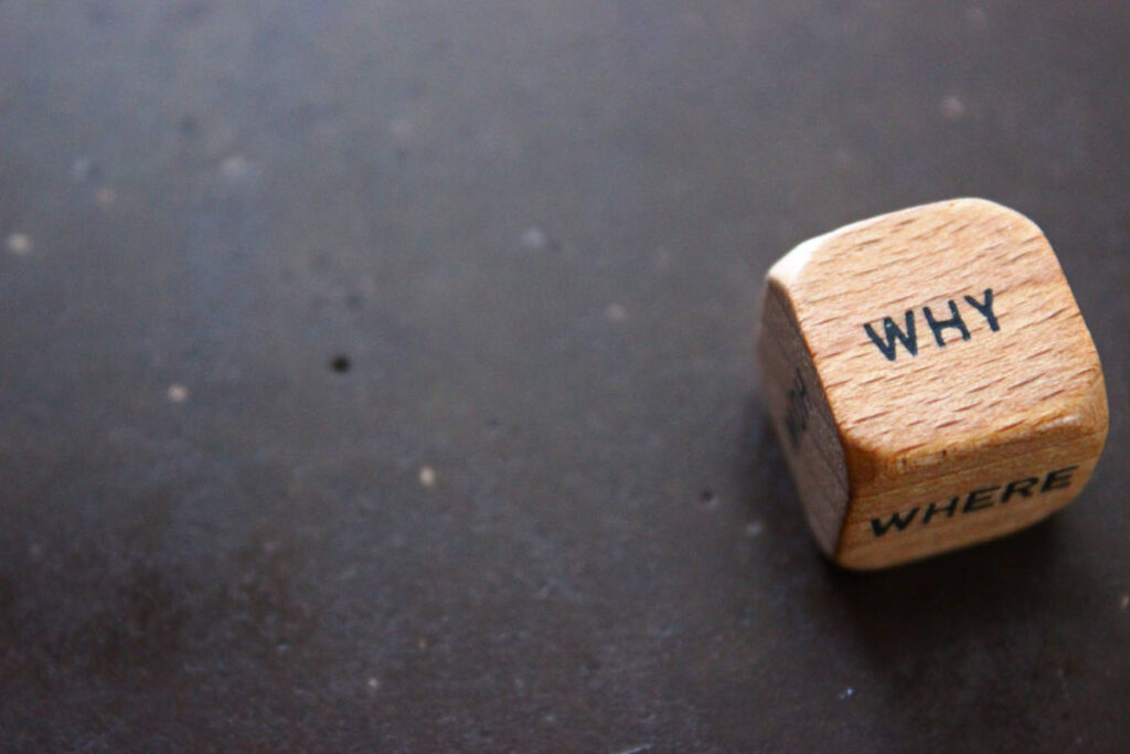 wooden word block containing the words "why" and where"