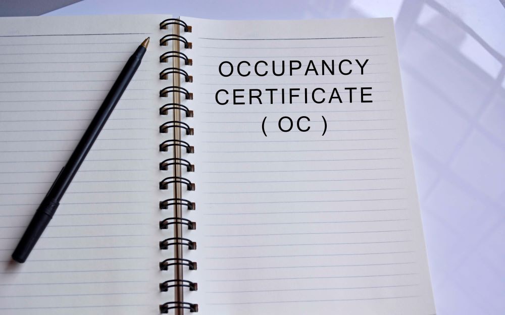 Occupancy certificate text written on a notepad with a pen on white table