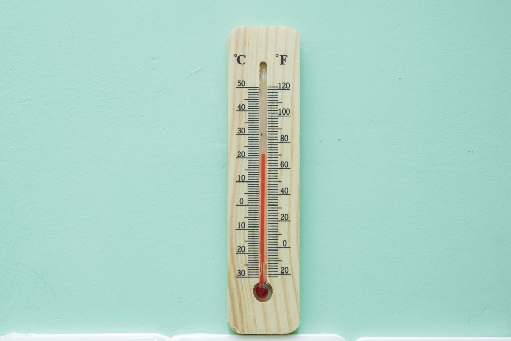 Thermometer on green background. Air temperature plus 21 degrees. Thermostat instrument to measure air temperature