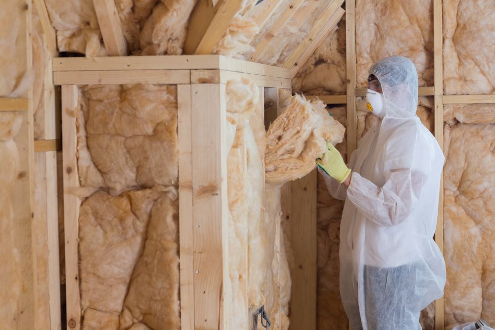 Worker filling walls with insulation material