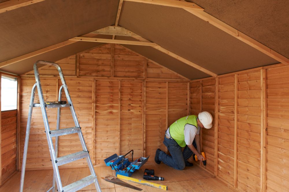 Contractor working on an interior of a shed building project