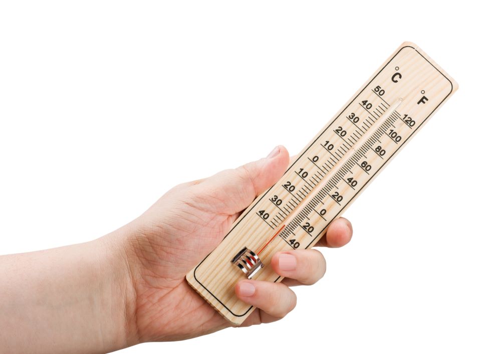 Hand holding a thermometer with low temperature