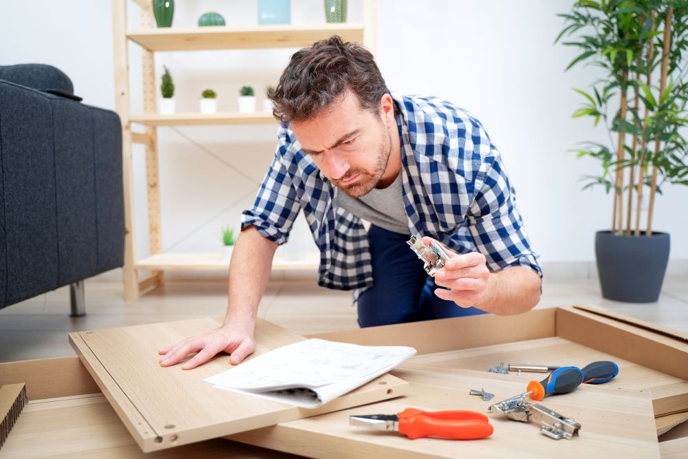 Man assembling furniture at home on the floor