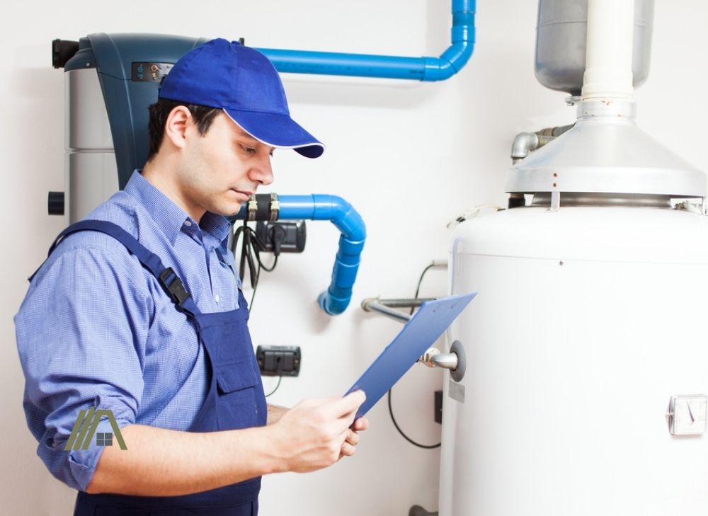technician reviewing notes of water heater after installation