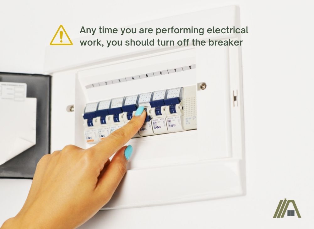 Any time you are performing electrical work, you should turn off the breaker, woman's hand turning off the breaker