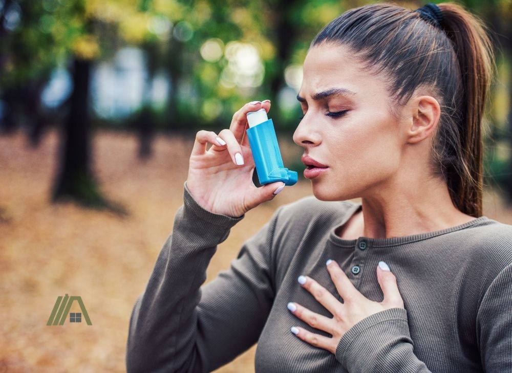 woman who has asthma holding_using an inhaler