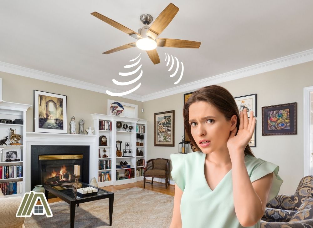 Ceiling fan humming inside the living room and a girl with her hand on her ear