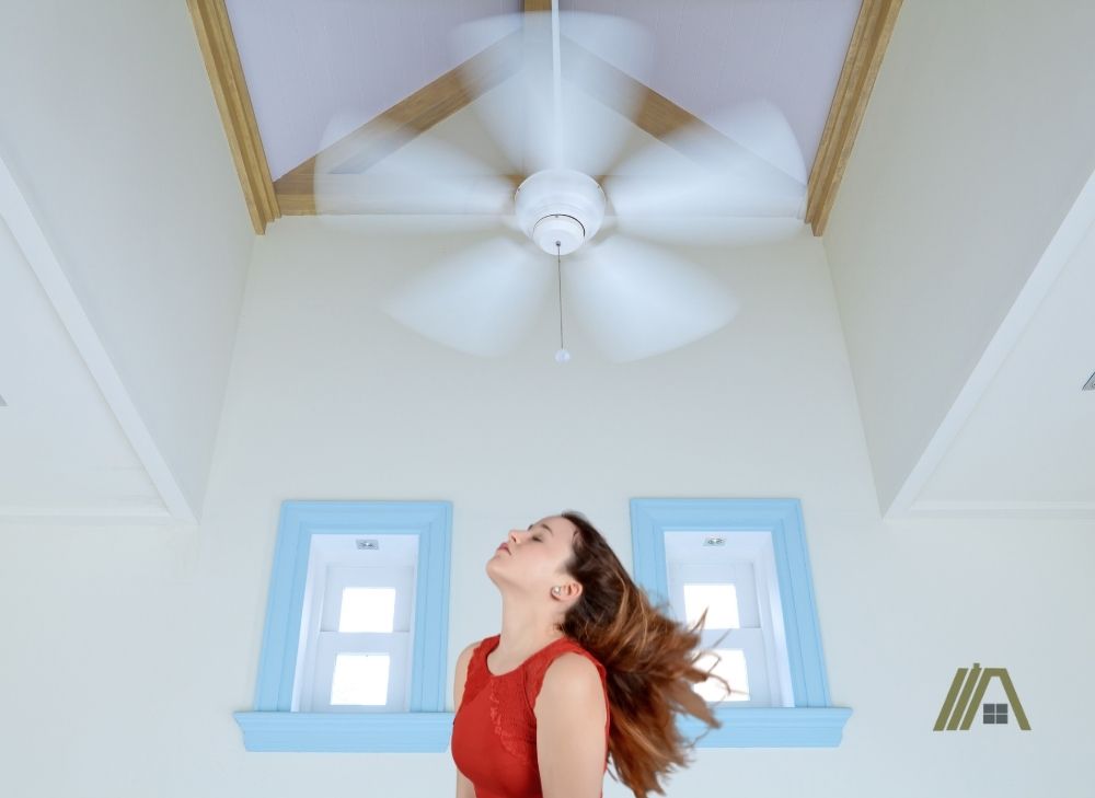 Girls hair blowing while she is below the ceiling fan