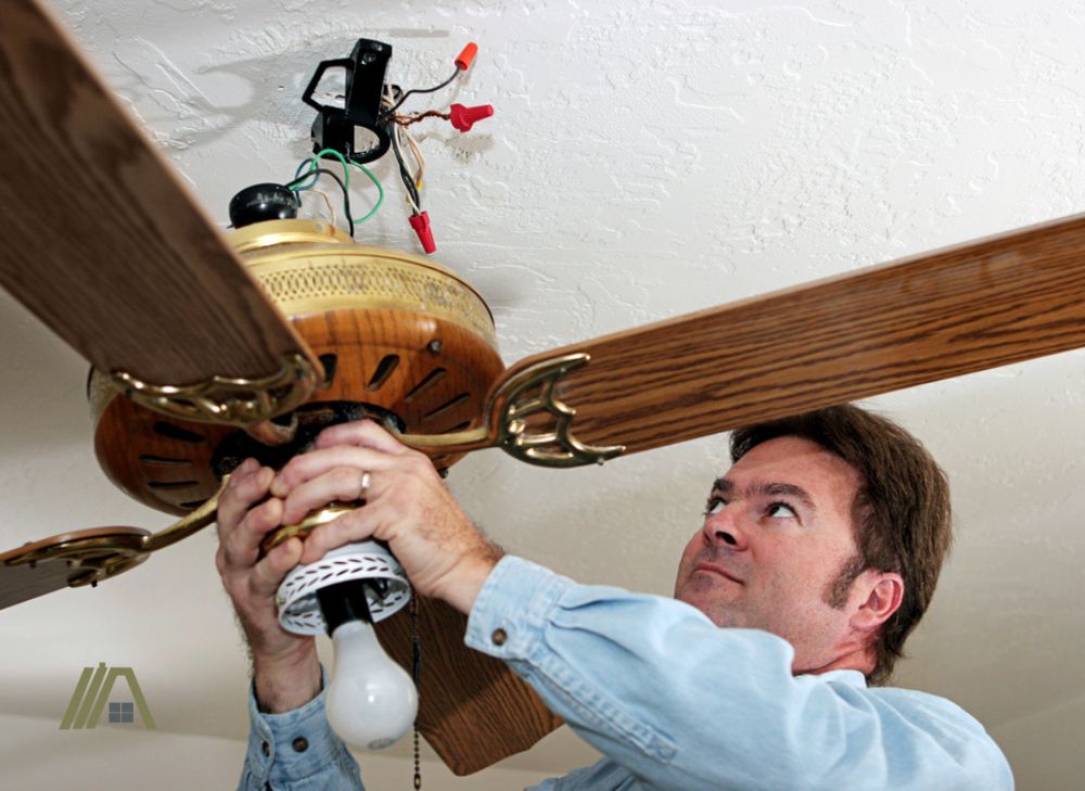 electrician checking the wiring of the ceiling fan