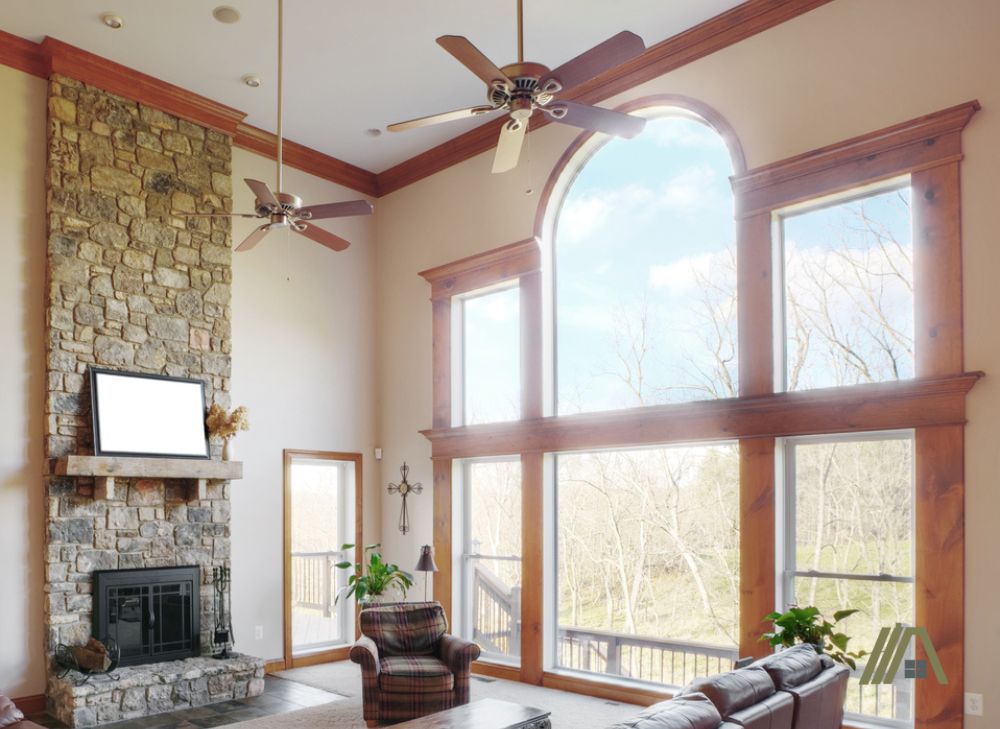 Living room with a fireplace under two ceiling fans