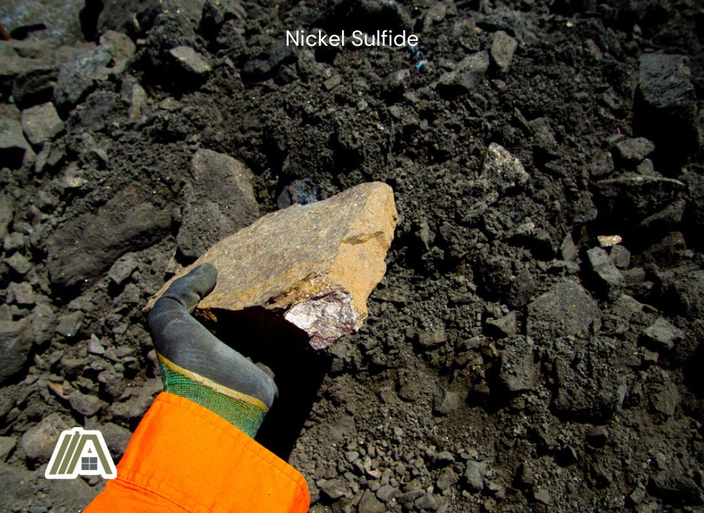 Man holding a rock with nickel sulfide