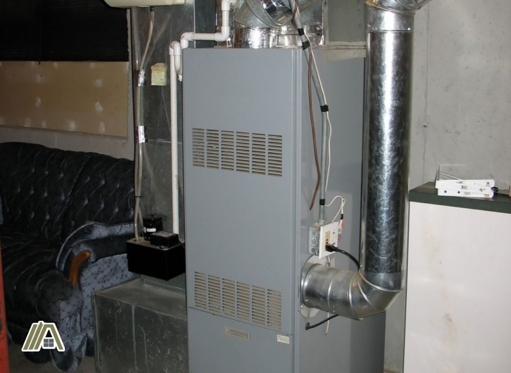 Gray modern floor furnace with ducts and wires attached to it