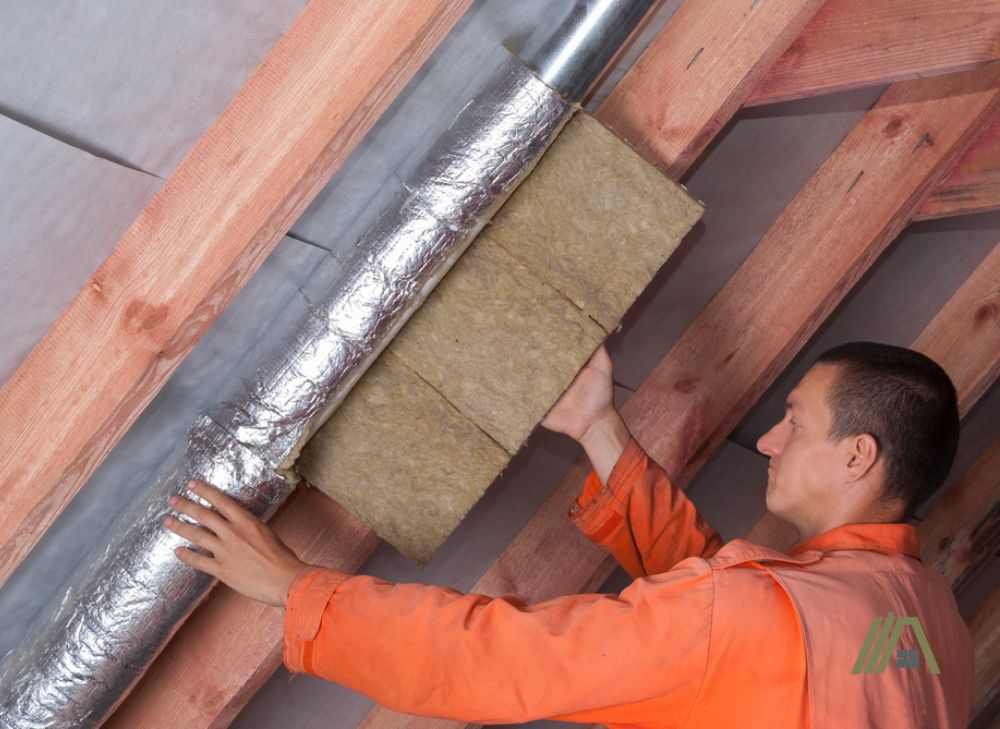 Man putting an insulation to an installed duct