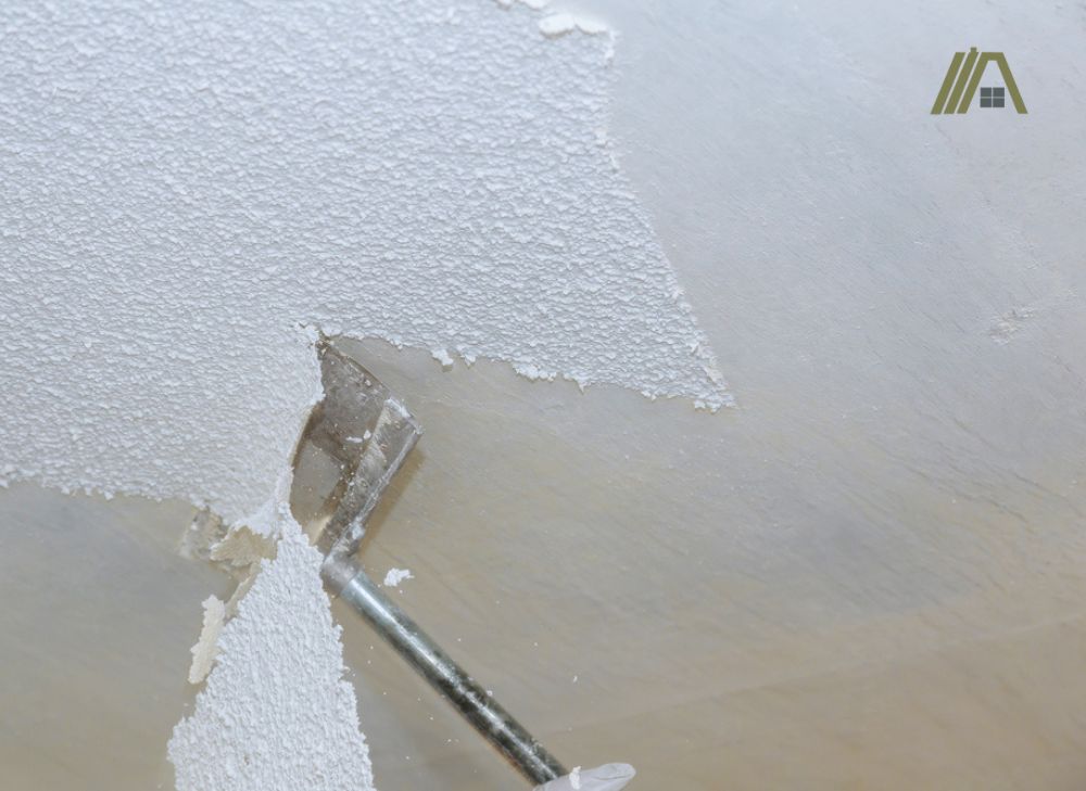 Man removing the popcorn ceiling by scraping it off