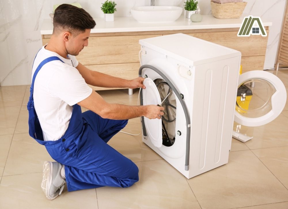 Professional plumber opening the white dryer at the back