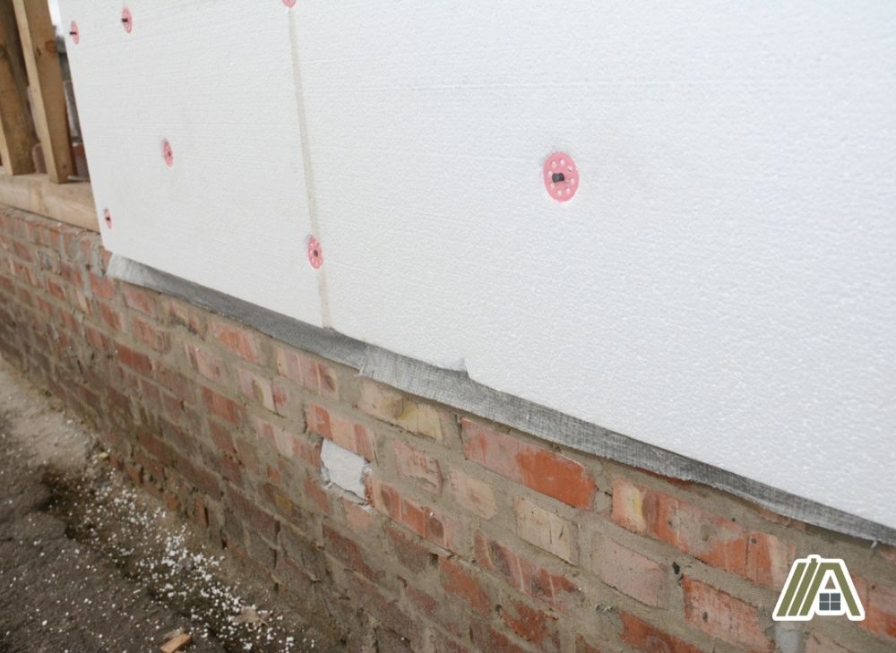 Installed polyurethane foam board insulation on a wall with bricks