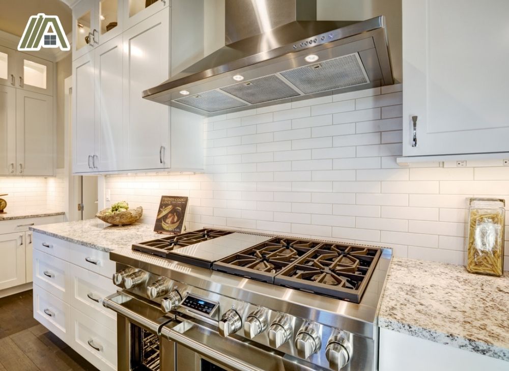 White themed kitchen with big six slots stainless steel gas stove and range hood