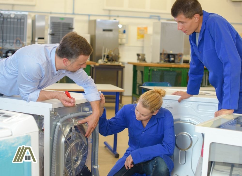 Three technicians checking and testing the dryers and washing machine.jpg