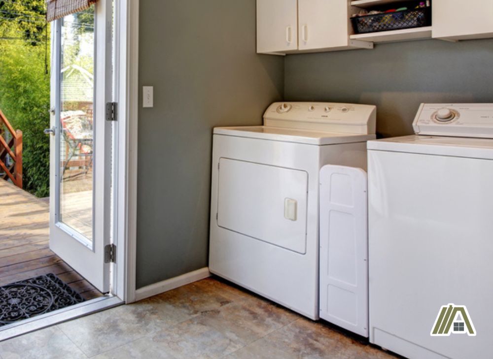 Gas dryer and a washer installed in a laundry room leading to backyard
