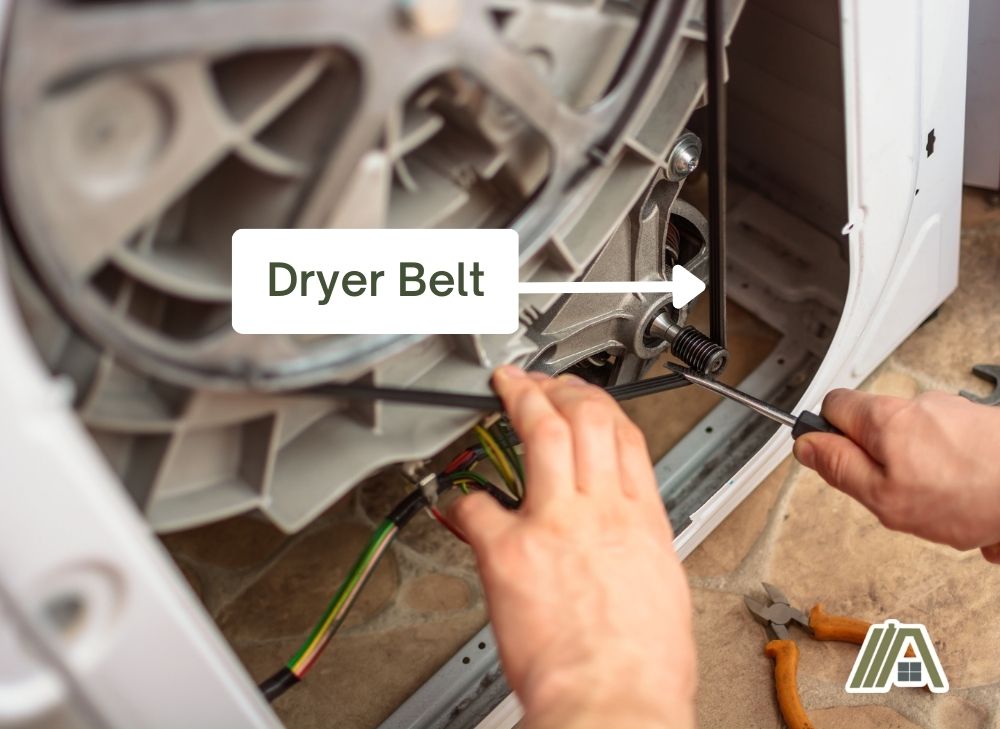 Man-fixing-the-dryer-belt-of-a-dryer