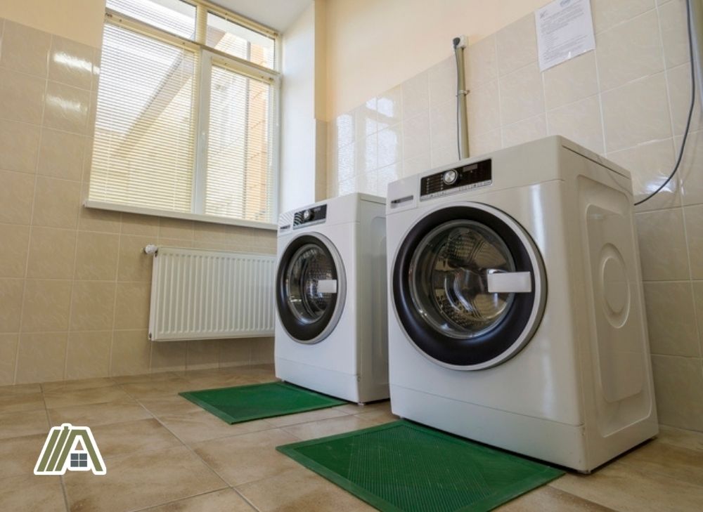 Washing machine and dryer inside a room with tiles installed