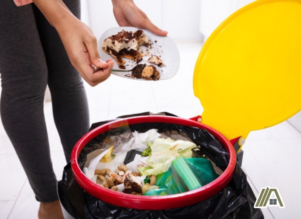 Woman disposing food to the trash bin
