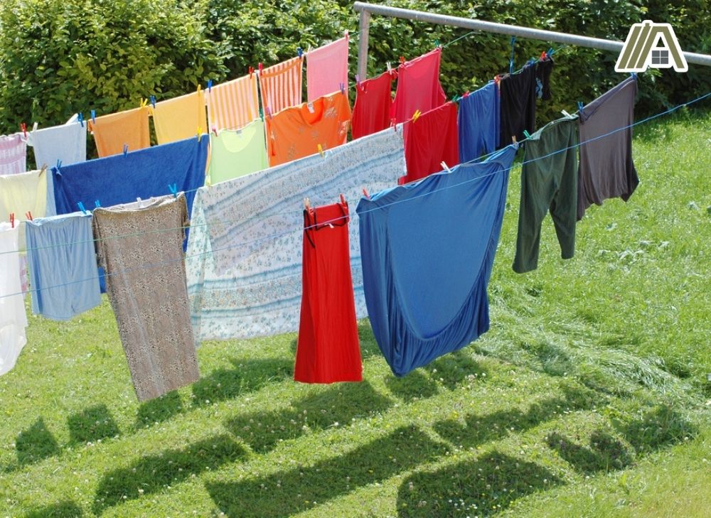 Colorful clothes and bed sheets placed in the laundry string, line drying of clothes in the backyard