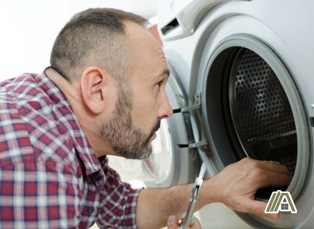 Man checking the inside of a dryer