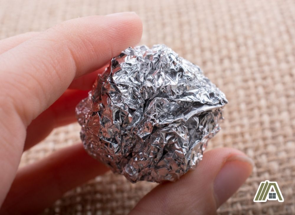 Man holding an aluminum foil ball