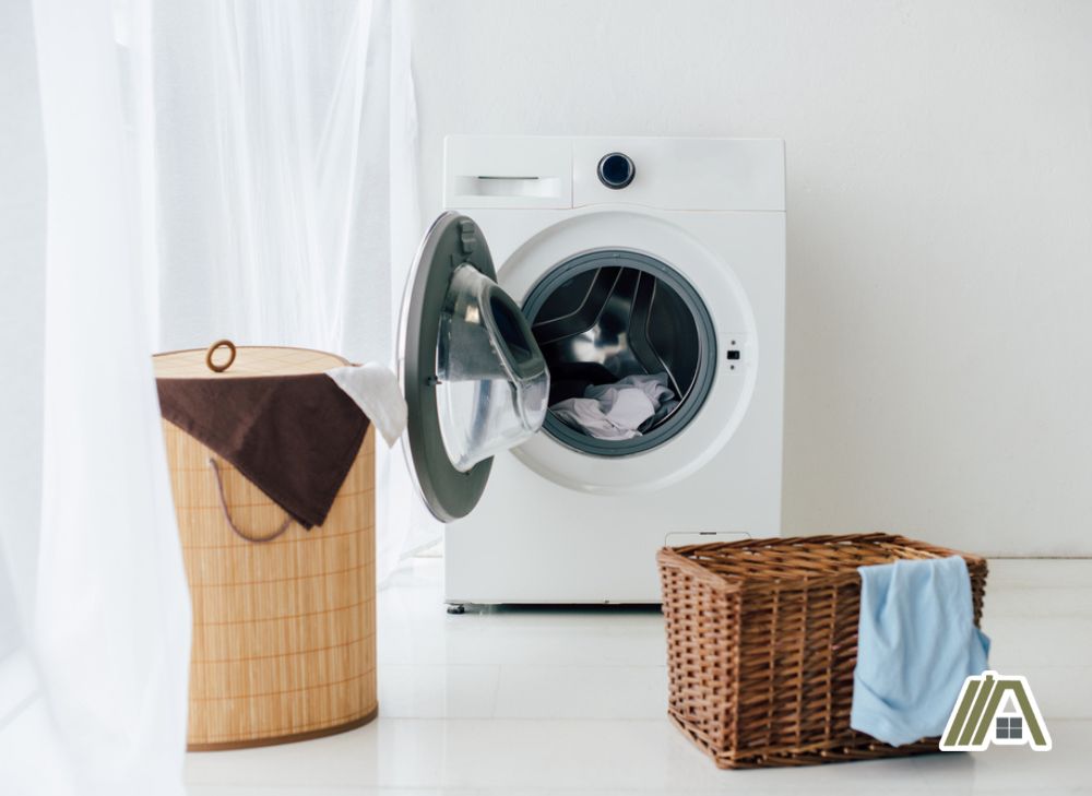 White open electric dryer with two rattan laundry baskets
