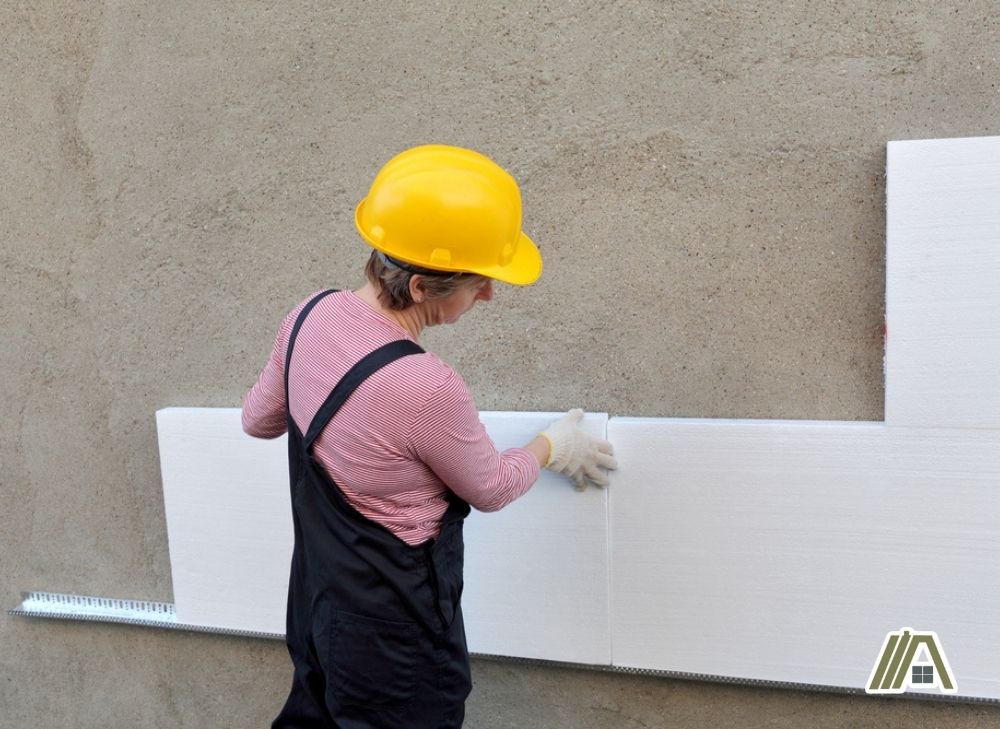 Woman installing a polystyrene insulation